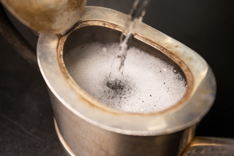 Teekanne wird zur Reinigung mit Wasser gefüllt